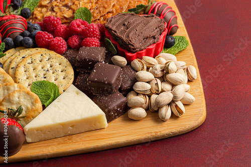 A Chocolate Covered Strawberries and Cheese Sweet Charcuterie Board on a Red Table
