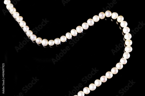 White pearls necklace on black background.