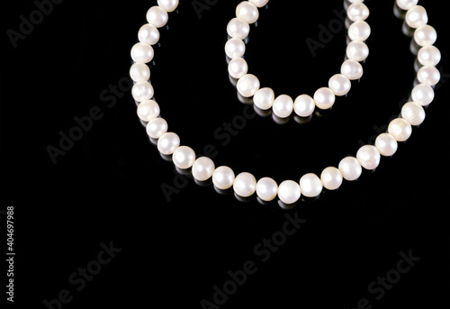 White pearls necklace on black background.