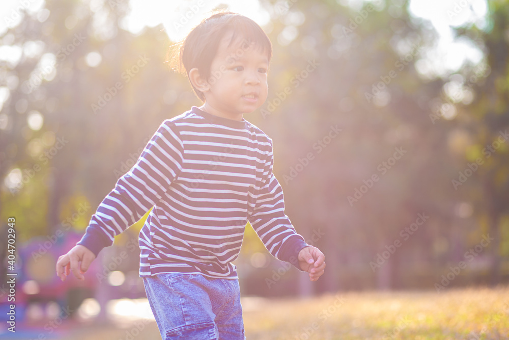 Little boy playing on green grass in park morning sunrise boy in nature Little boy playing on green grass in park morning sunrise boy in nature