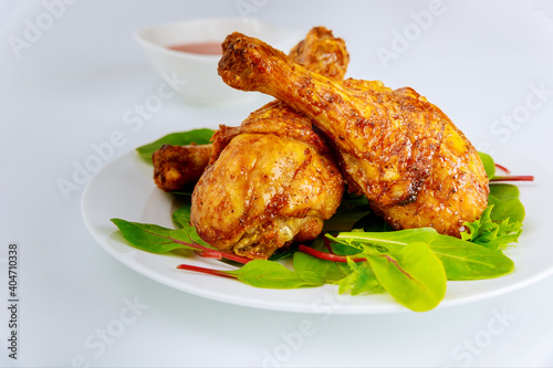 Roasted turkey drumsticks with salad on white background,