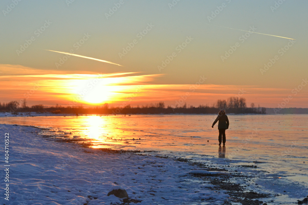 Winter Sea Golden Sunset. Walk on the ice dunes of a frozen lake in winter at sunset.