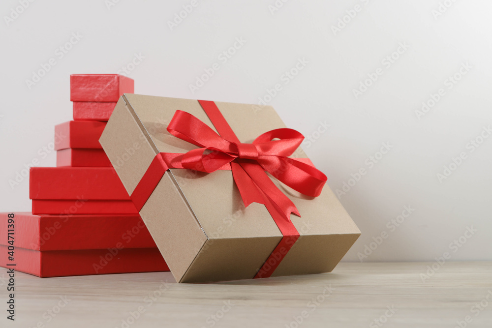 Brown gift box and red ribbon on wooden background with space Brown gift box and red ribbon on wooden background with space