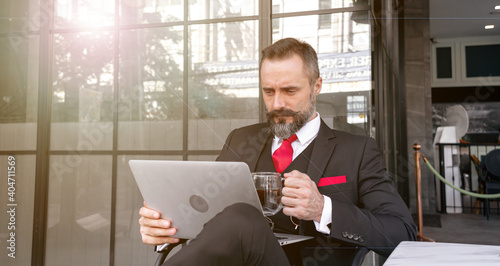 Businessman planning project in his mind, analyzing many data information with serious face, nervous face of a man in suit with coffee cup, laptop outdoor city background.