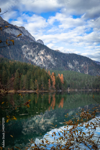 Esmerald lake and mountains in autumn with a cloudy sky and yellow trees © Gus