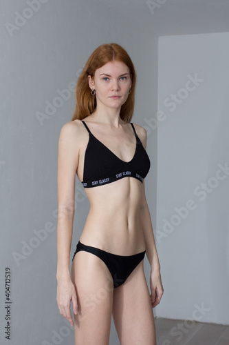 snap shot of pretty model in black lingerie on white background with red hair  © Zaliya