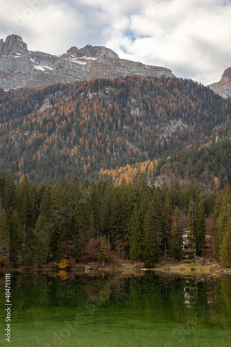 Esmerald lake and mountains in autumn with a cloudy sky and yellow trees