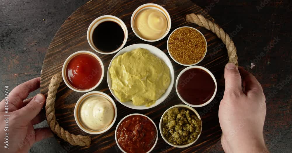 Men's hands are put on table with different types of sauces. Men's hands are put on table with different types of sauces.