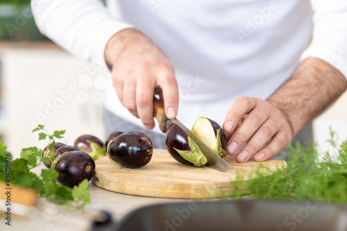 Man hands preparing healthy breakfast of eggplant at home kitchen