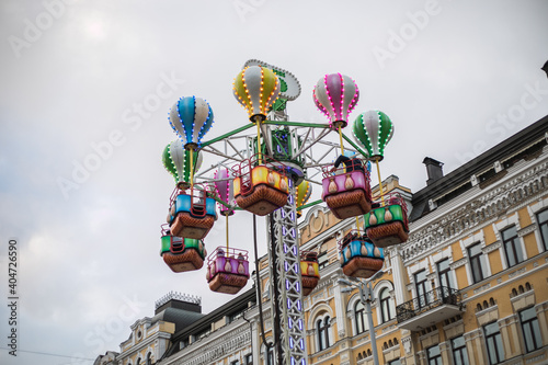 Kids riding on fairground carousel merry-go-round out outdoor funfair, Kiev City Ukraine