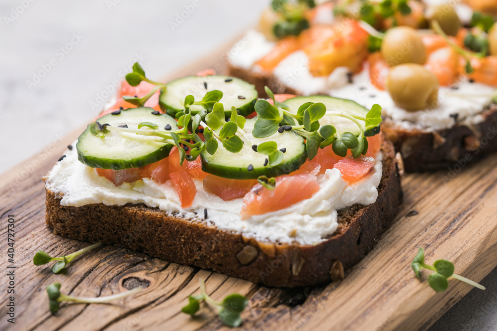 Salmon toast with a micro-green on  wooden background,  concept of healthy eating,  assortment of bruschetta