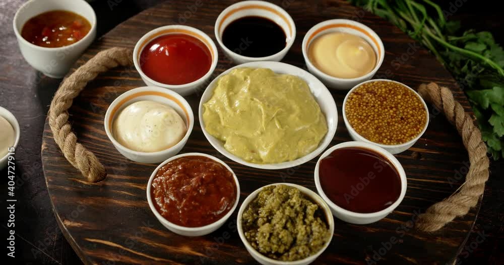 The wooden tray with different aromatic sauces rotates. The wooden tray with different aromatic sauces rotates.