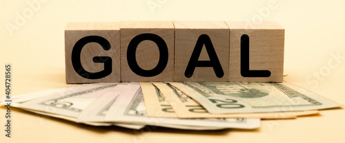 the word goal on wooden cubes and American dollars