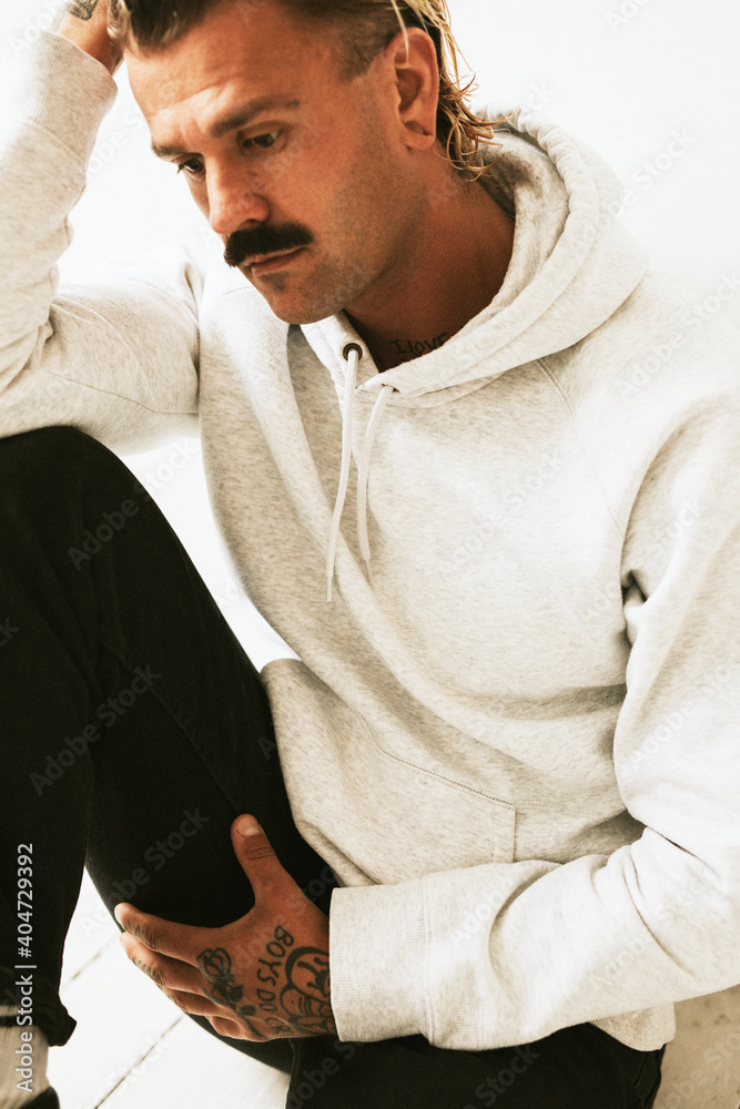 Alternative tattooed man in hoodie studio shot Alternative tattooed man in hoodie studio shot