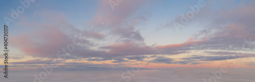 Sunrise panorama in lilac and pale pink shades with cirrus clouds. Sky background. View from the plane during the flight on vacation
