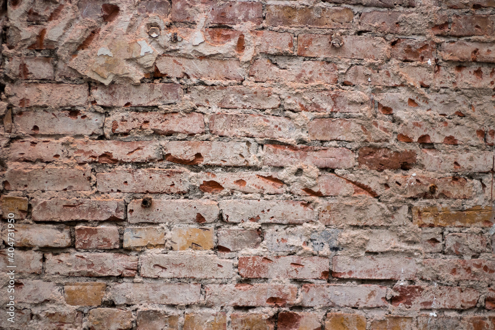 Brick texture from old stone. 18th century brick wall. Old burnt brick masonry. Shooting details close-up. Aged red clay color. Rectangular blocks laid out in rows and held together with cement. Brick texture from old stone. 18th century brick wall. Old burnt brick masonry. Shooting details close-up. Aged red clay color. Rectangular blocks laid out in rows and held together with cement.