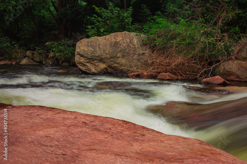 Smooth and silky flow of water in Thirumoorthy Falls (also knows as Panchalingam Falls in tamil language), Udumalpet, Tamil Nadu, India. Selective focus photo