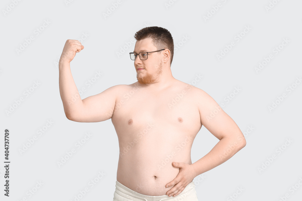 Overweight man on grey background. Weight loss concept Overweight man on grey background. Weight loss concept