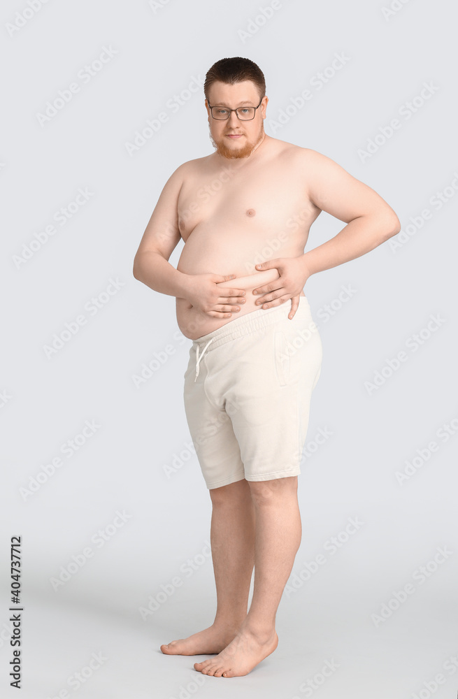 Overweight man on grey background. Weight loss concept Overweight man on grey background. Weight loss concept