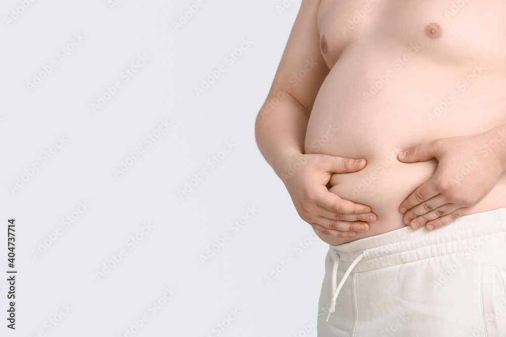 Overweight man on grey background. Weight loss concept Overweight man on grey background. Weight loss concept
