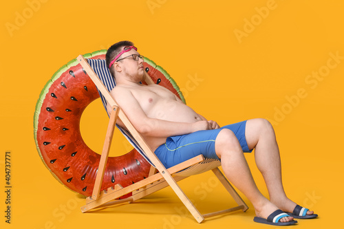 Overweight man sitting on b...