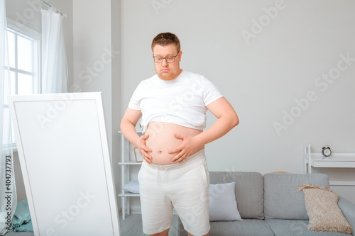 Sad overweight man near mir...