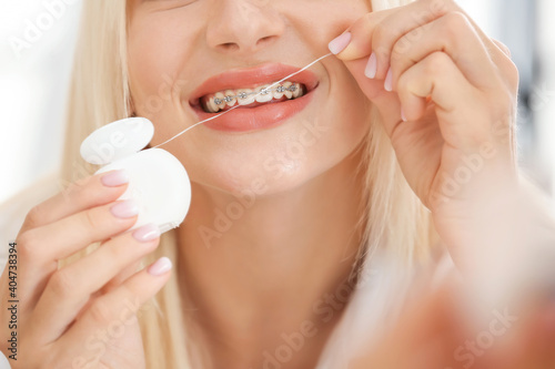 Young woman with dental braces and floss  closeup
