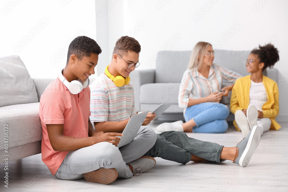 Teenagers with different devices at home - obrazy, fototapety, plakaty 