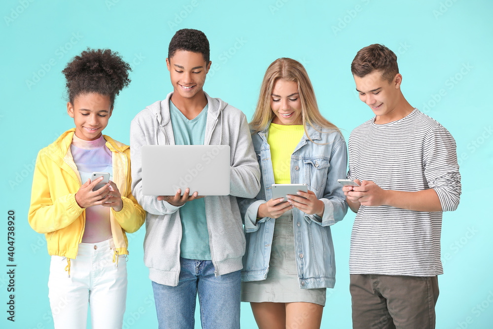 Teenagers with different devices on color background Teenagers with different devices on color background