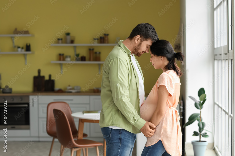 Young pregnant couple at home