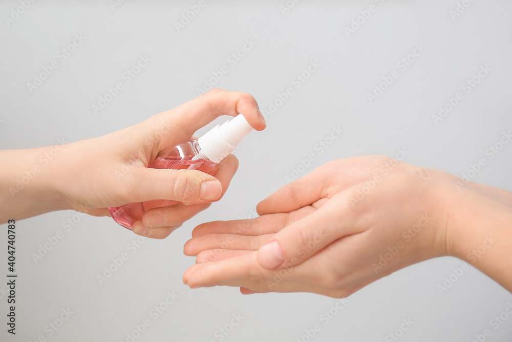 People with sanitizer on grey background People with sanitizer on grey background