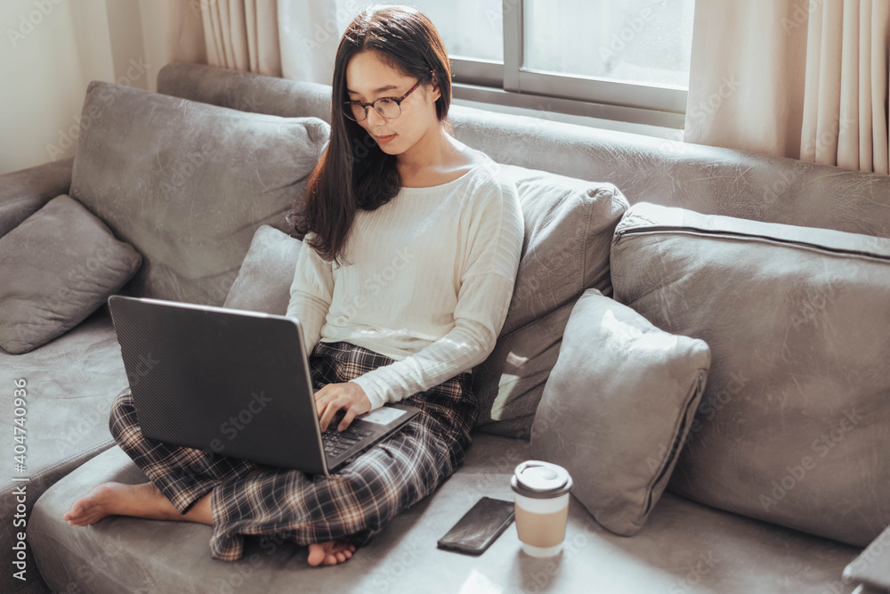 Young woman working on laptop and sitting at home. Beautiful busineeswoman working at home and smiling. Working at home during Coronavirus or Covid-19 quarantine. Young woman working on laptop and sitting at home. Beautiful busineeswoman working at home and smiling. Working at home during Coronavirus or Covid-19 quarantine.