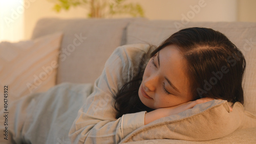 夜、ソファーでうたた寝する若い女性