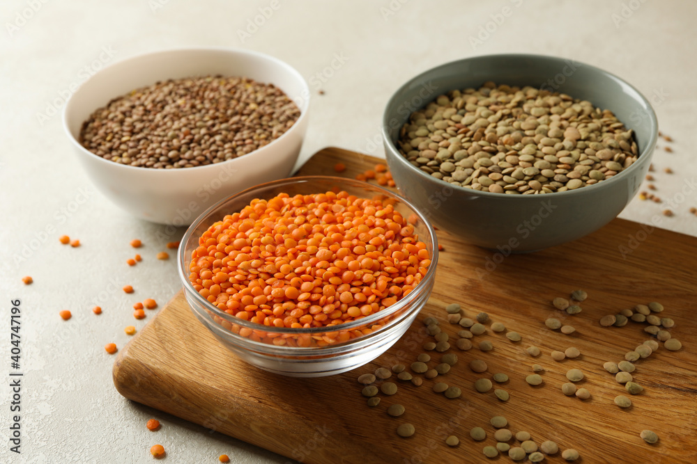Board with bowls with legumes on white textured background Board with bowls with legumes on white textured background