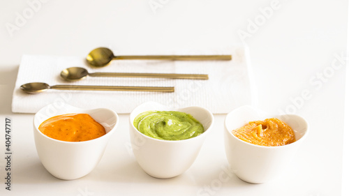 Three typical Canary Islands sauces, mojo picon, mojo verde  and almogrote  in ceramic bowl on modern restaurant table photo