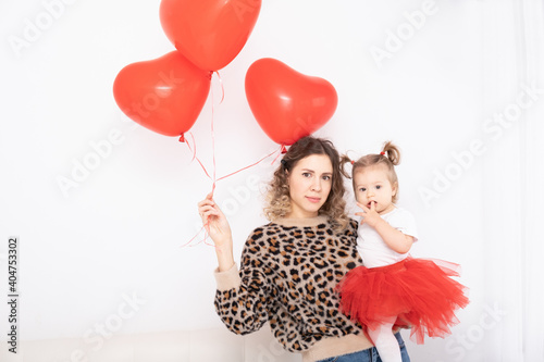 beautiful young mother holds cute baby girl and heart balloons. © Юля Шевцова