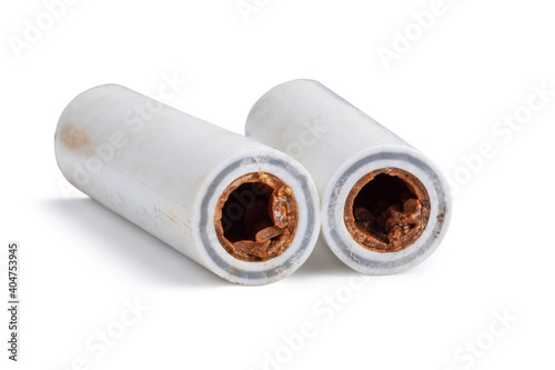 Old broken sludge plumbing polypropylene pipes with red rust and limescale. Corrosion, sludge and hard water concept. Obsolete pipes isolated on white background