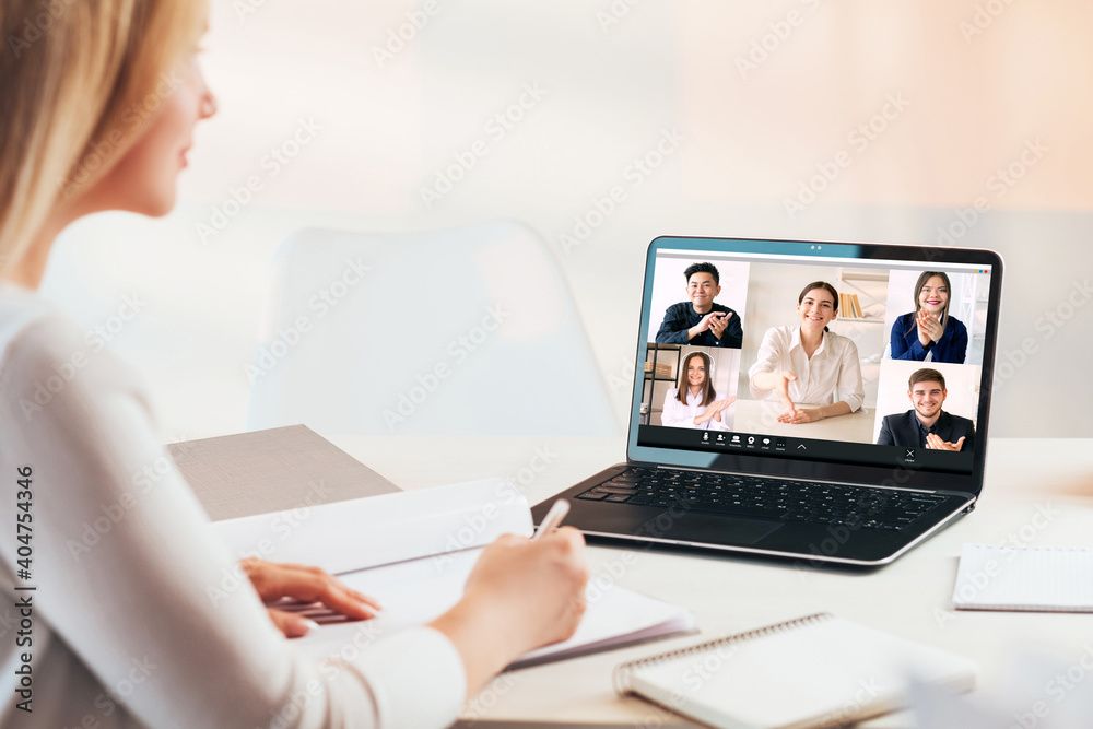 Video chat. Virtual meeting. Online job interview. Distance recruitment. Female HR manager watching employee greeting team on laptop screen in light modern home office with copy space.