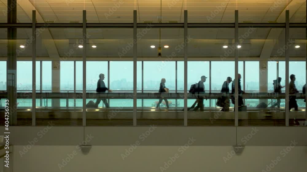 Silhouette of some people walking on the moving walkway, embarking from the airport of New York during the Covid-19 pandemic.