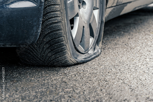 flat car tire close up, punctured wheel photo