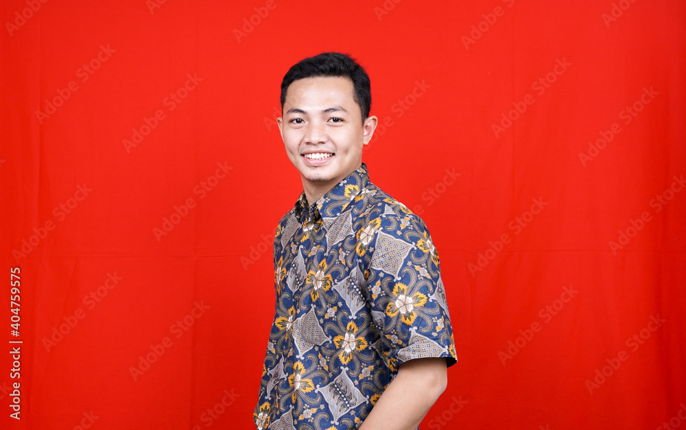 asian man stylish with batik clothes in studio isolated with red background asian man stylish with batik clothes in studio isolated with red background