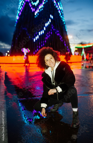 Obraz na płótnie Happy smiling woman posing at night street festive square. Christmas, New Year celebration, winter holidays conception. w salonie