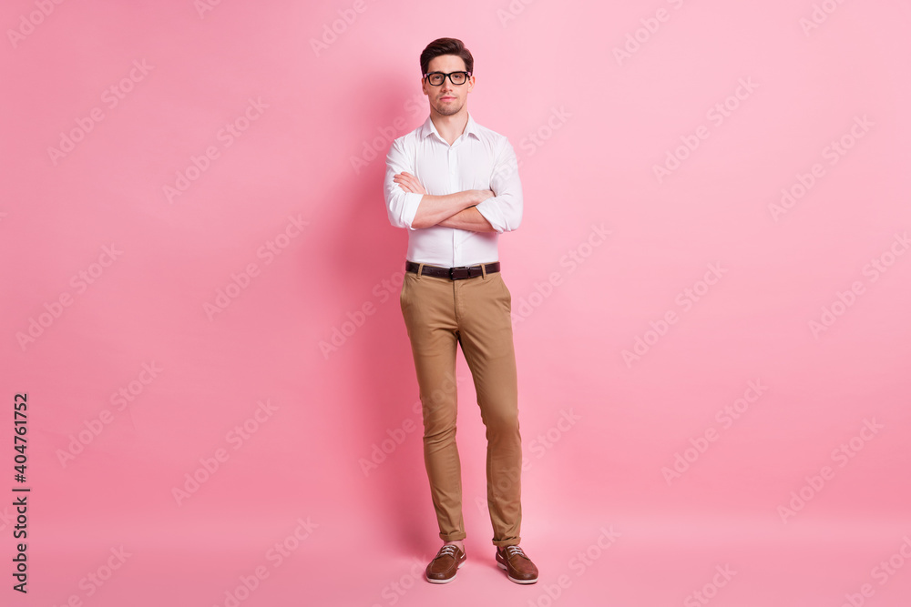 Full size photo of serious guy crossed arms wear spectacles white shirt trousers sneakers isolated on pink color background