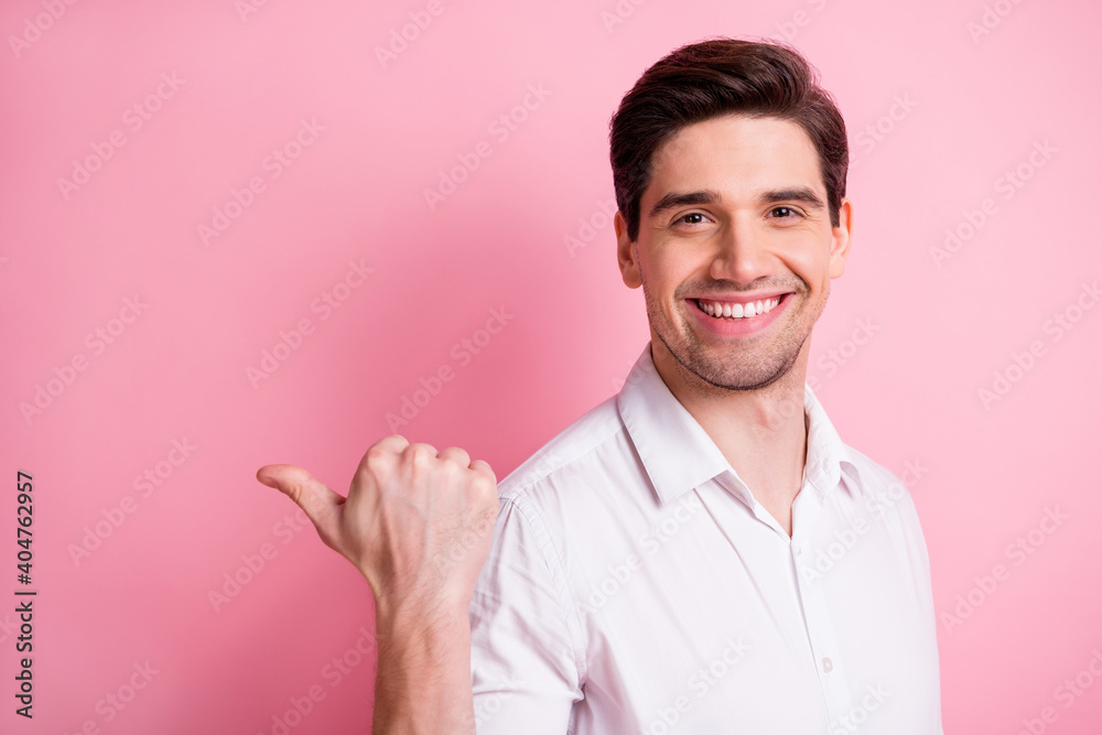 Photo of satisfied young man toothy smile direct thumb empty space novelty isolated on pink color background Photo of satisfied young man toothy smile direct thumb empty space novelty isolated on pink color background