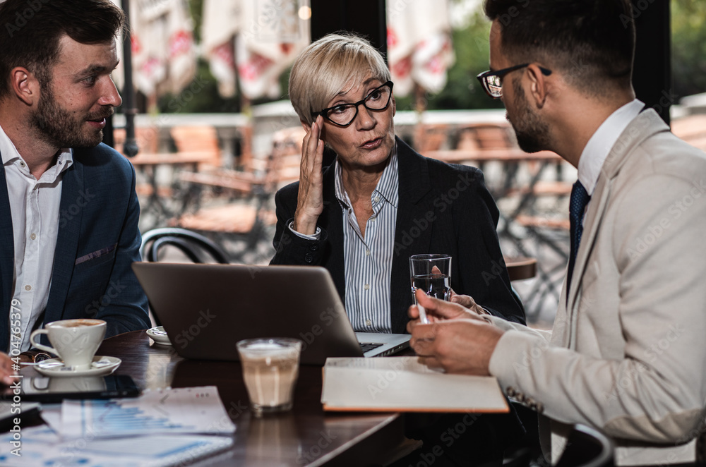 Business people holding a meeting at office cafeteria discussing about business plan. Business people holding a meeting at office cafeteria discussing about business plan.