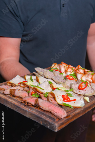 Meat platter with selection of different kinds of meat and sausages served on a wooden board. photo