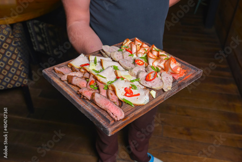 Meat platter with selection of different kinds of meat and sausages served on a wooden board. photo