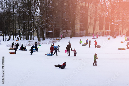 People entertaining with sledding, white snow, sun light