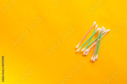 Minimalist background with cotton swabs on a yellow background.