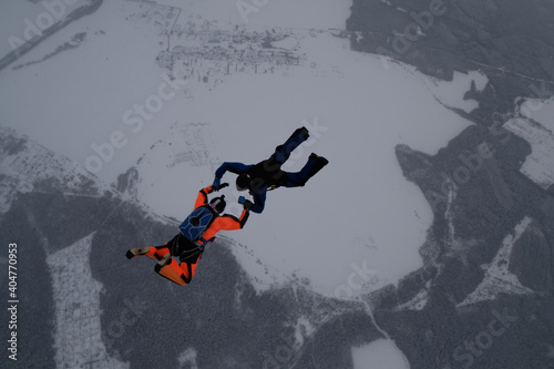 Skydiving. Two skydivers are training in the winter sky.